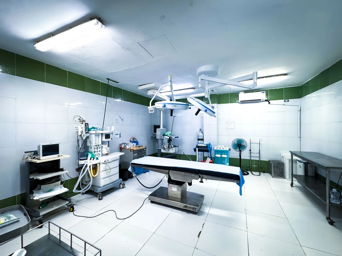 Sala cirúrgica com equipamentos médicos, sem pacientes.
