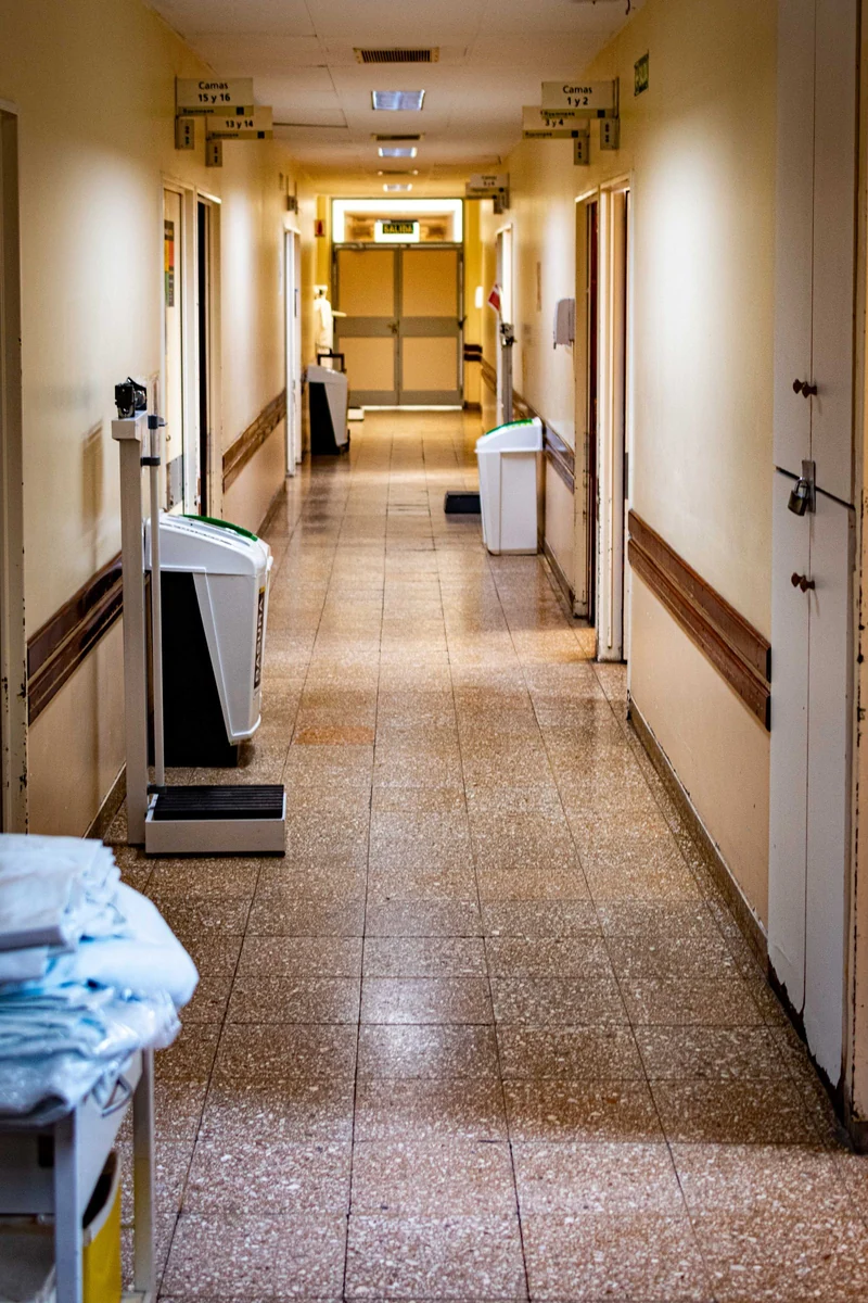 Corredor hospitalar com equipamentos médicos, sem pessoas identificáveis.